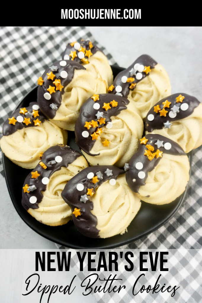 New Year's Eve Dipped Butter Cookies on a black plate with gray napkin and concrete backdrop