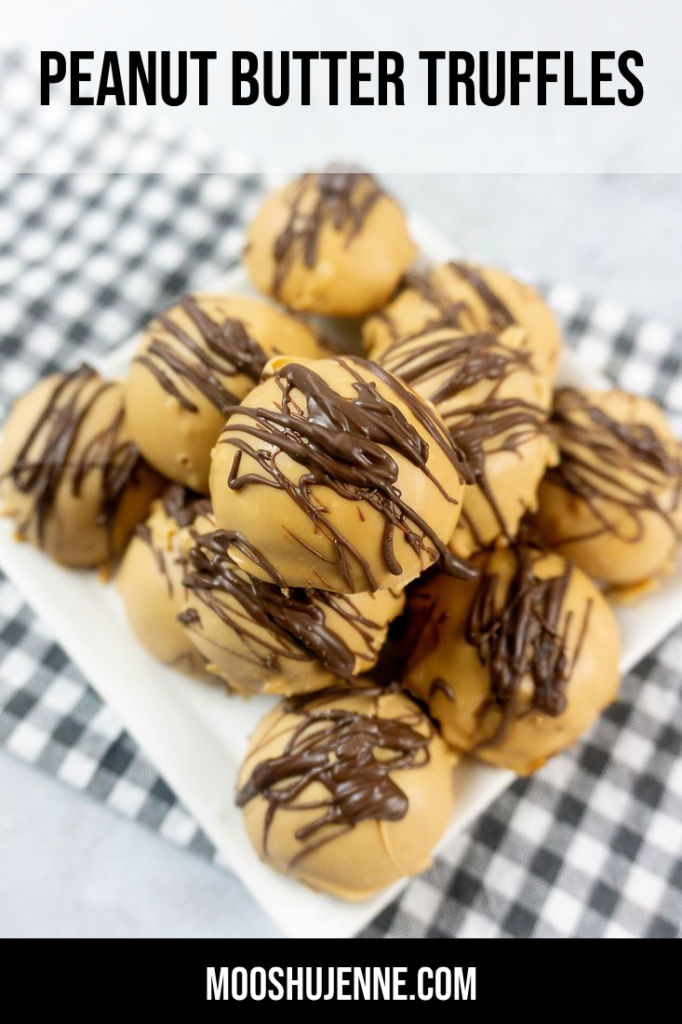 Peanut Butter Truffles drizzled with milk chocolate on a white plate with a gray plaid napkin and concrete back drop