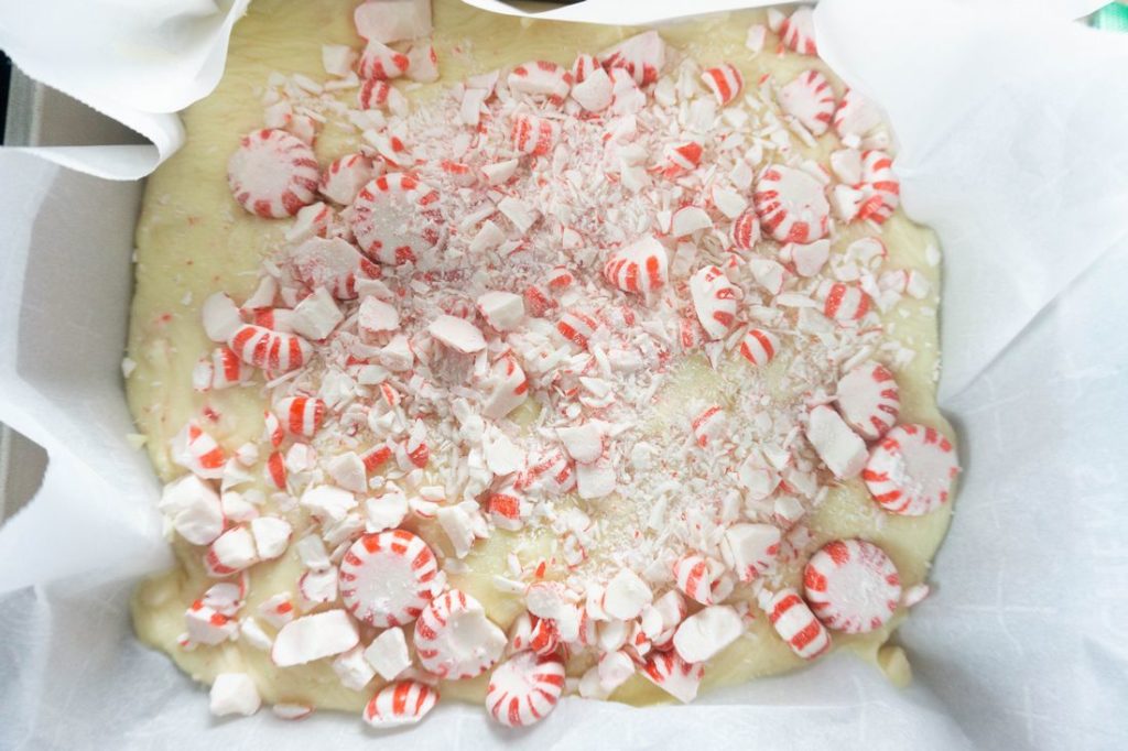 peppermint candy fudge in a pan lined with parchment paper