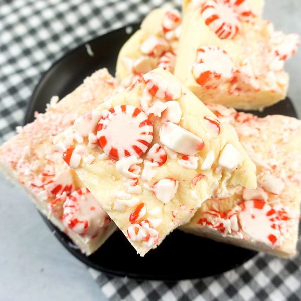 Peppermint Candy Fudge on a black plate with gray plaid napkin on a concrete backdrop