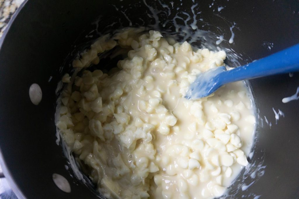 Melted white chocolate chips and sweetened condensed milk in a pan