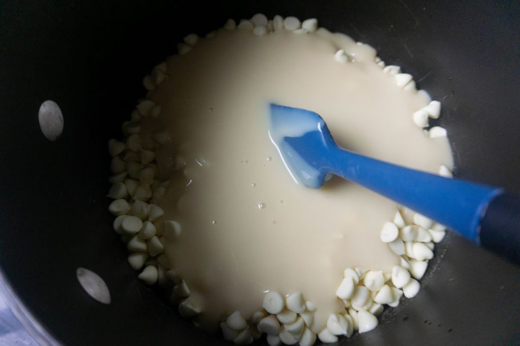 Melted white chocolate chips and sweetened condensed milk in a pan