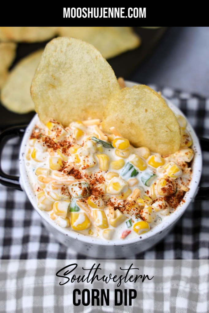 Southwestern Corn Dip in a white and black speckled bowl with a gray plaid napkin on a concrete backdrop