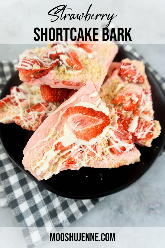 Strawberry shortcake bark on a black plate with gray plaid napkin on a concrete backdrop