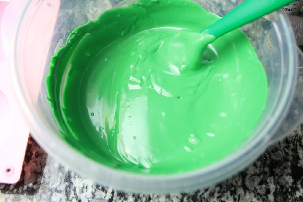 Dark green candy melts in a plastic bowl