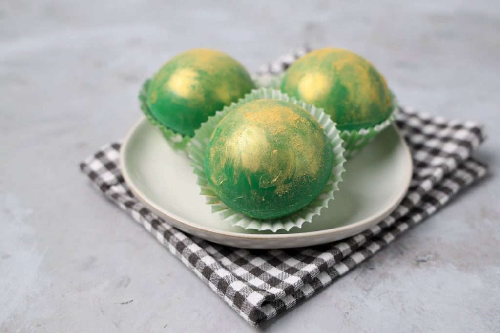 Irish Whiskey Hot Chocolate Bombs on a white plate with gray plaid napkin and concrete backdrop