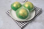 Irish Whiskey Hot Chocolate Bombs on a white plate with gray plaid napkin and concrete backdrop