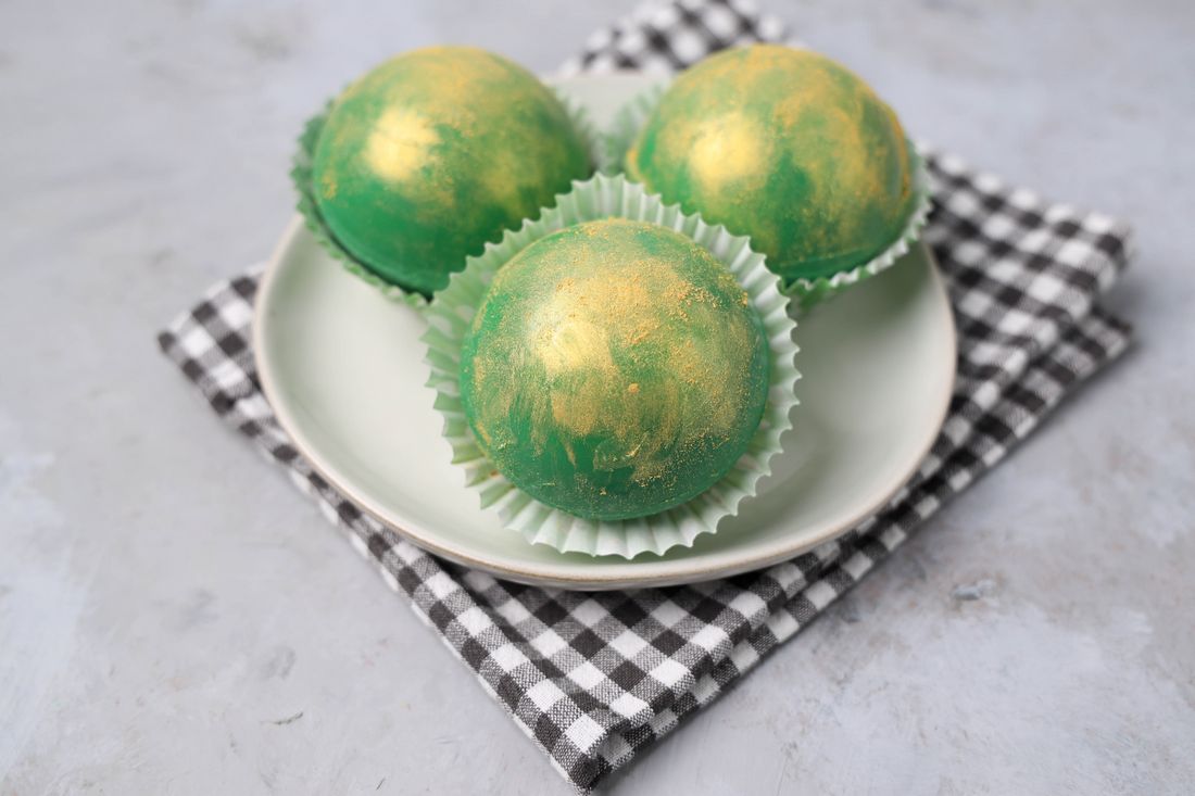 Irish Whiskey Hot Chocolate Bombs on a white plate with gray plaid napkin and concrete backdrop