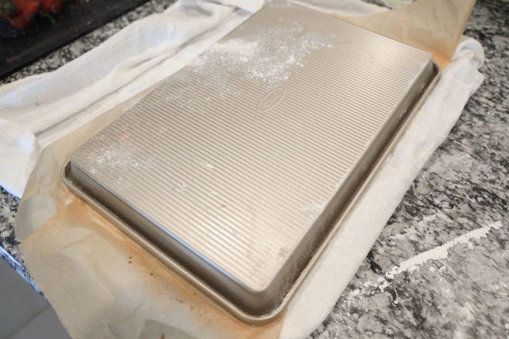 cake flipped over onto a cutting board and flour sack towel