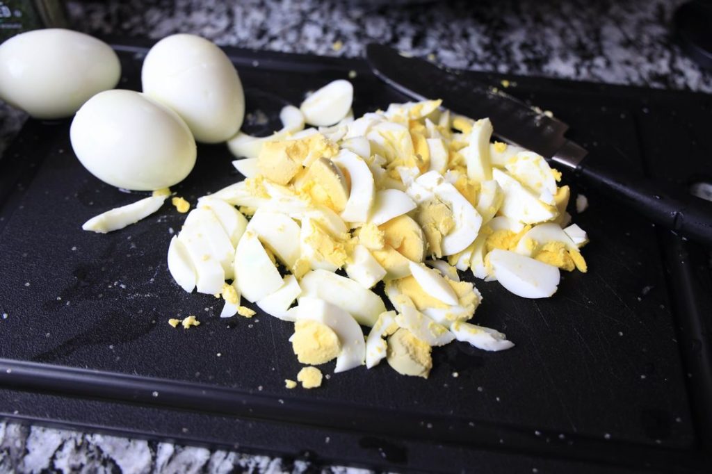 Chopped eggs on a black cutting board