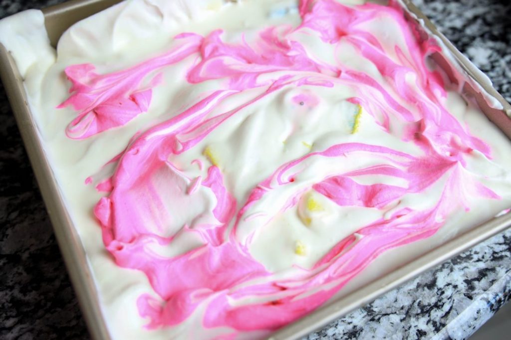Pink and white ice cream swirled into a baking pan