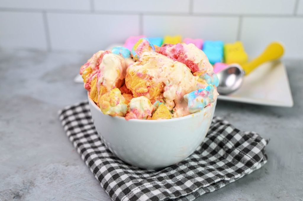 Peeps Ice Cream in a white bowl on a gray plaid napkin on a concrete backdrop