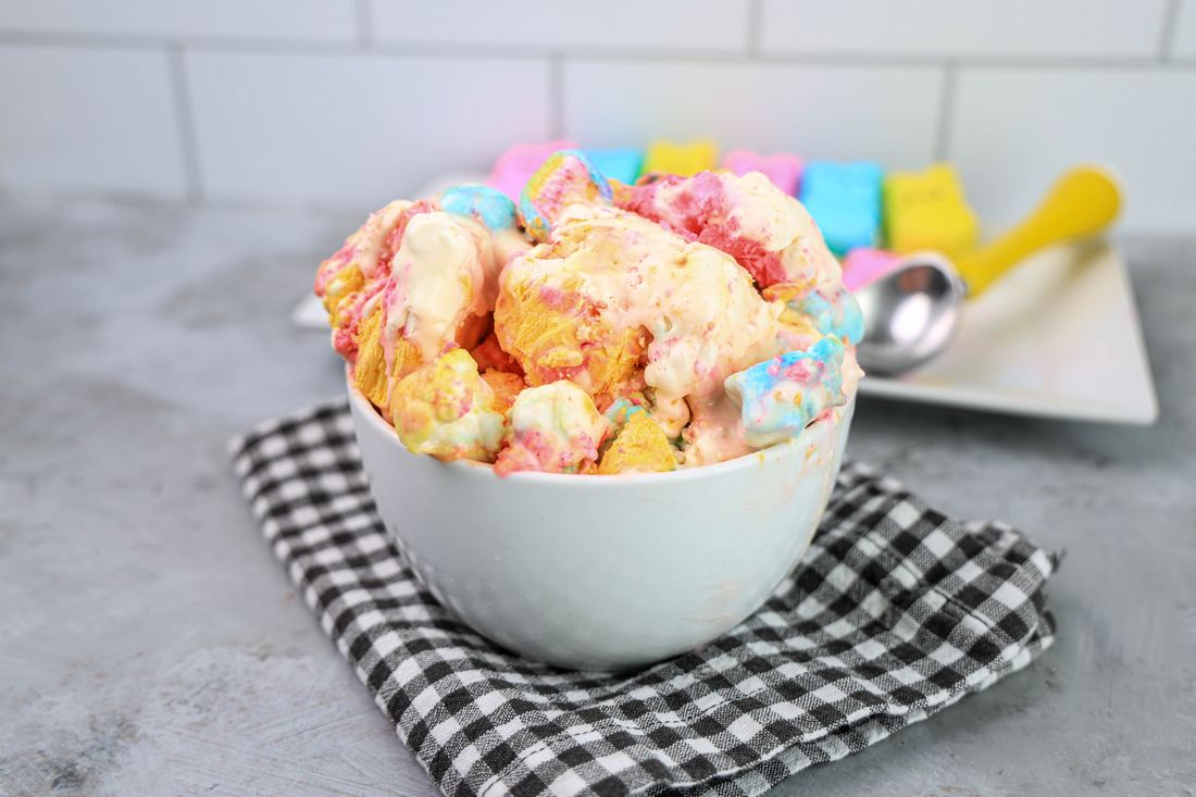 Peeps Ice Cream in a white bowl on a gray plaid napkin on a concrete backdrop