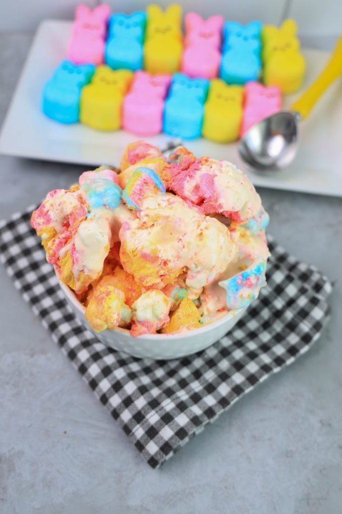 Peeps Ice Cream in a white bowl on a gray plaid napkin on a concrete backdrop