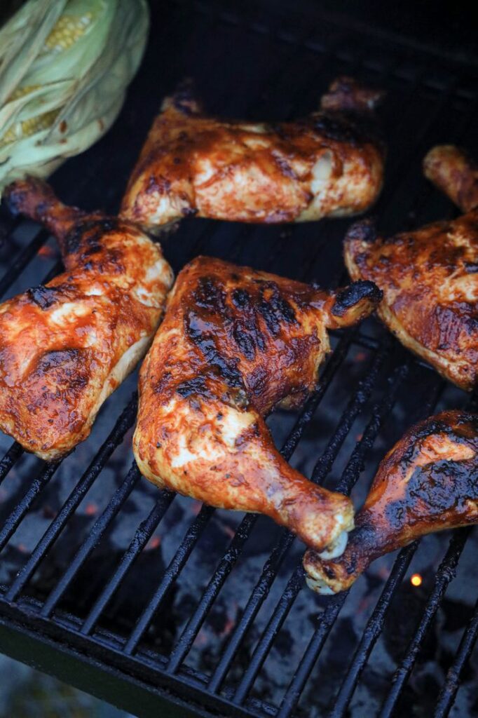 Chicken quarters on the grill with barbecue sauce