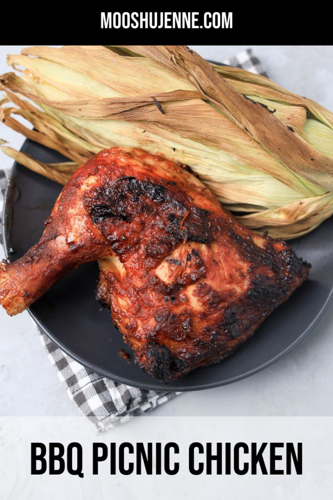 BBQ Picnic Chicken on a gray plate with gray plaid napkin on a concrete backdrop