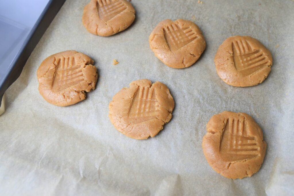 Peanut butter cookies on a baking sheet lined with parchment paper