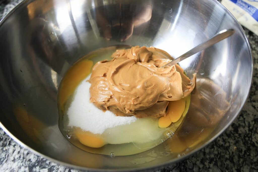 Ingredients for peanut butter cookies in a metal bowl