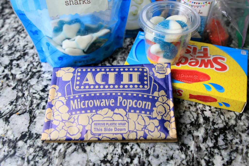 shark gummies, swedish fish, gummy rings, and white chocolate items to make shark week popcorn.