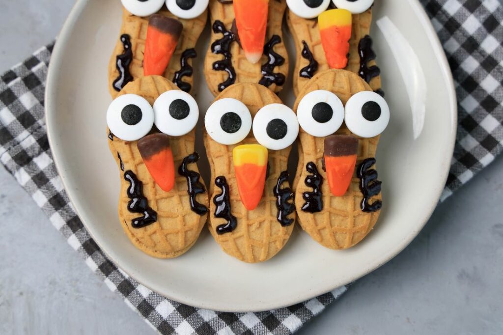 Nutter Butter Owls on a white plate on a plaid napkin with concrete backdrop