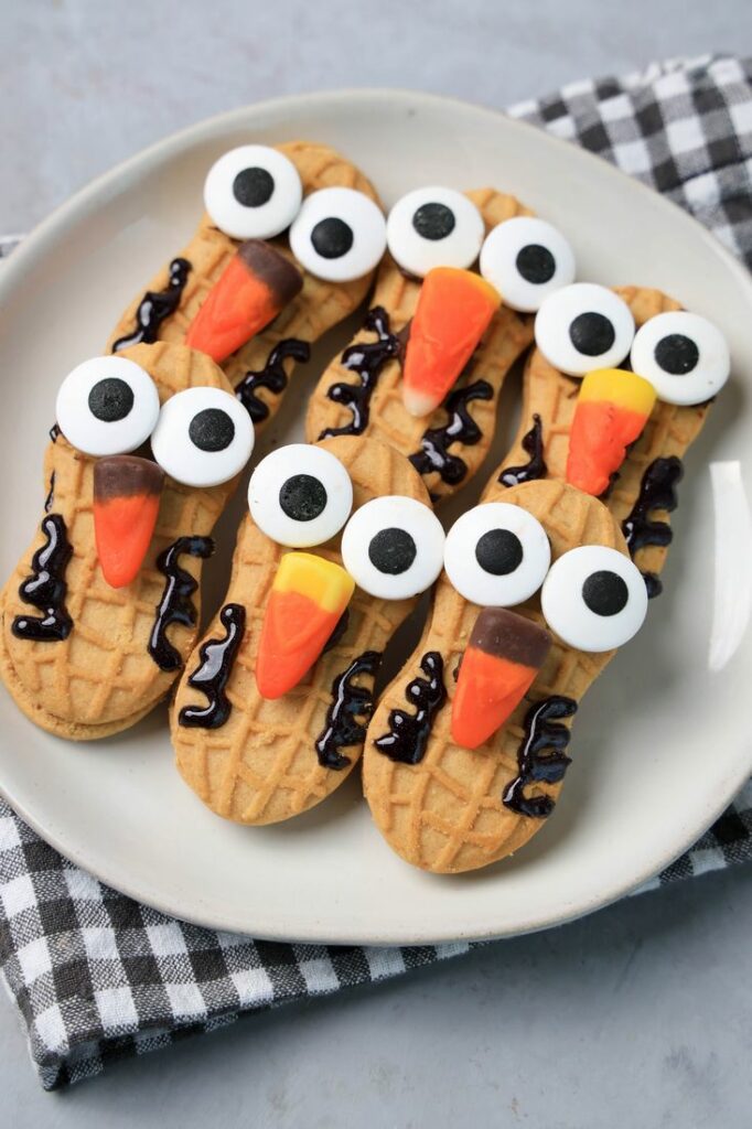 Nutter Butter Owls on a white plate on a plaid napkin with concrete backdrop