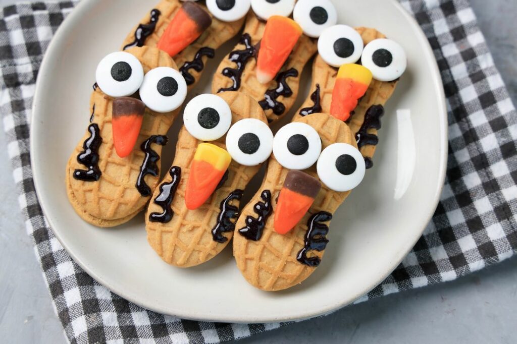 Nutter Butter Owls on a white plate on a plaid napkin with concrete backdrop