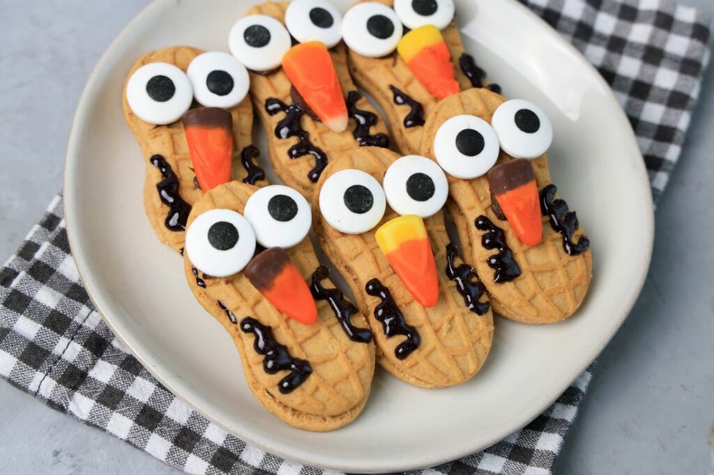 Nutter Butter Owls on a white plate on a plaid napkin with concrete backdrop