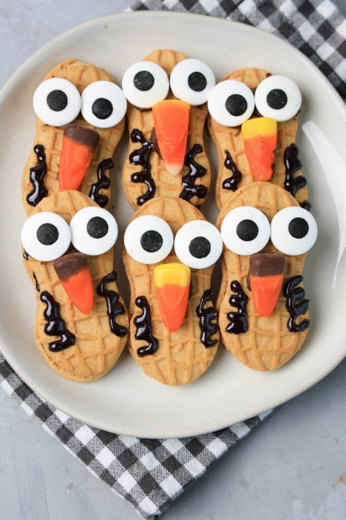 Nutter Butter Owls on a white plate on a plaid napkin with concrete backdrop