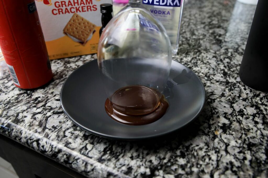 Glass on a plate of chocolate syrup.