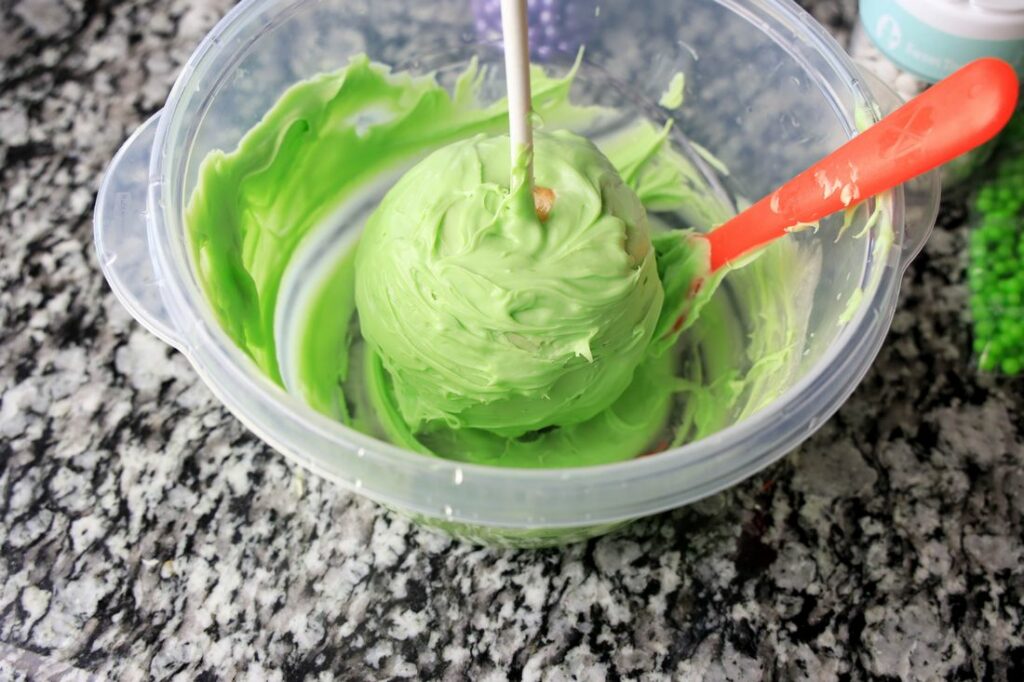 Green candy melts on a candied apple.