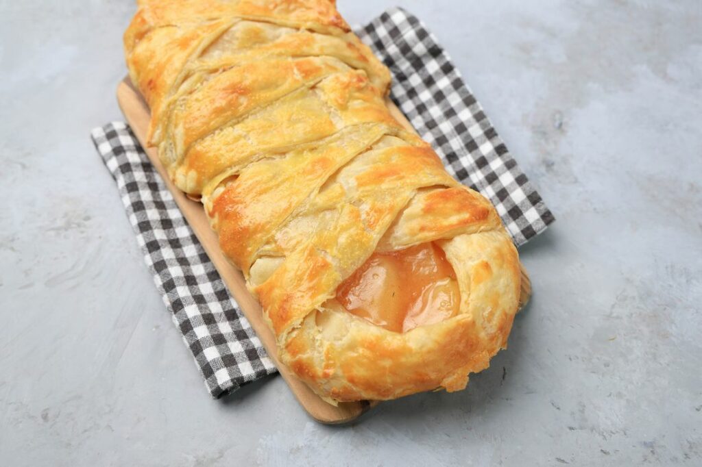 Apple Pie Braid on a wood board on a plaid napkin.