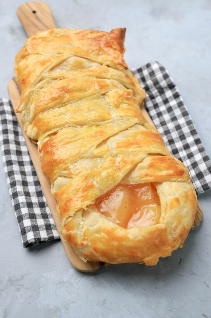 Apple Pie Braid on a wood board on a plaid napkin.