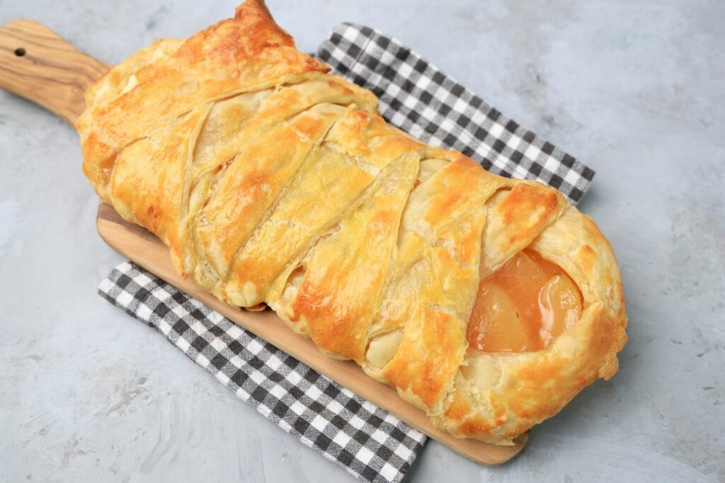 Apple Pie Braid on a wood board on a plaid napkin.