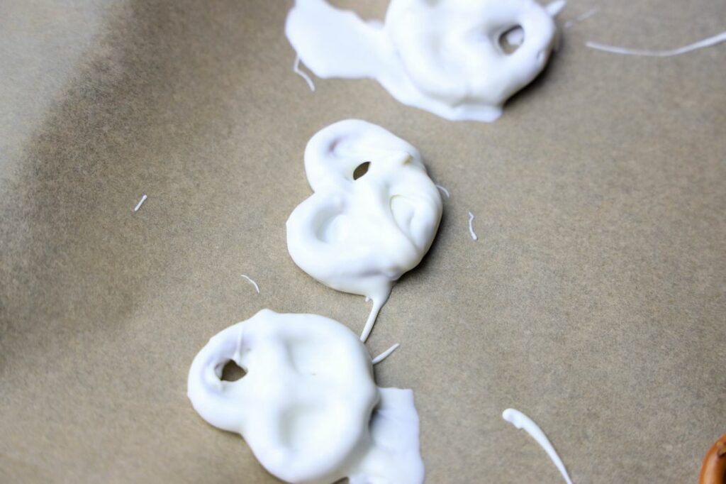 Chocolate covered pretzels on parchment paper.