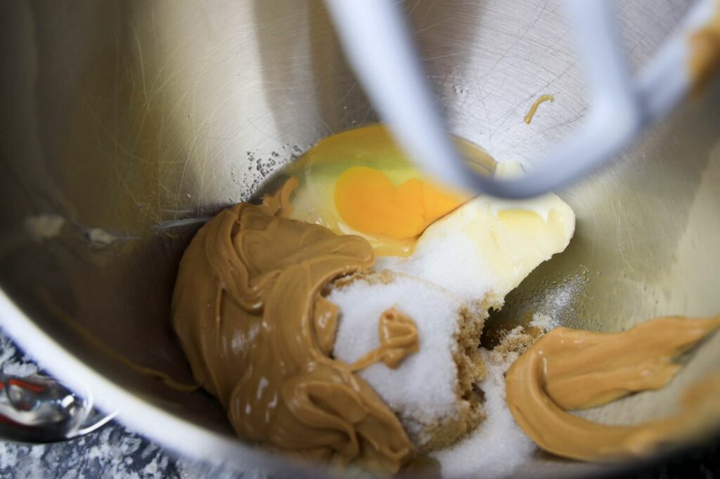 Peanut butter, egg, brown sugar and sugar in a mixer bowl.