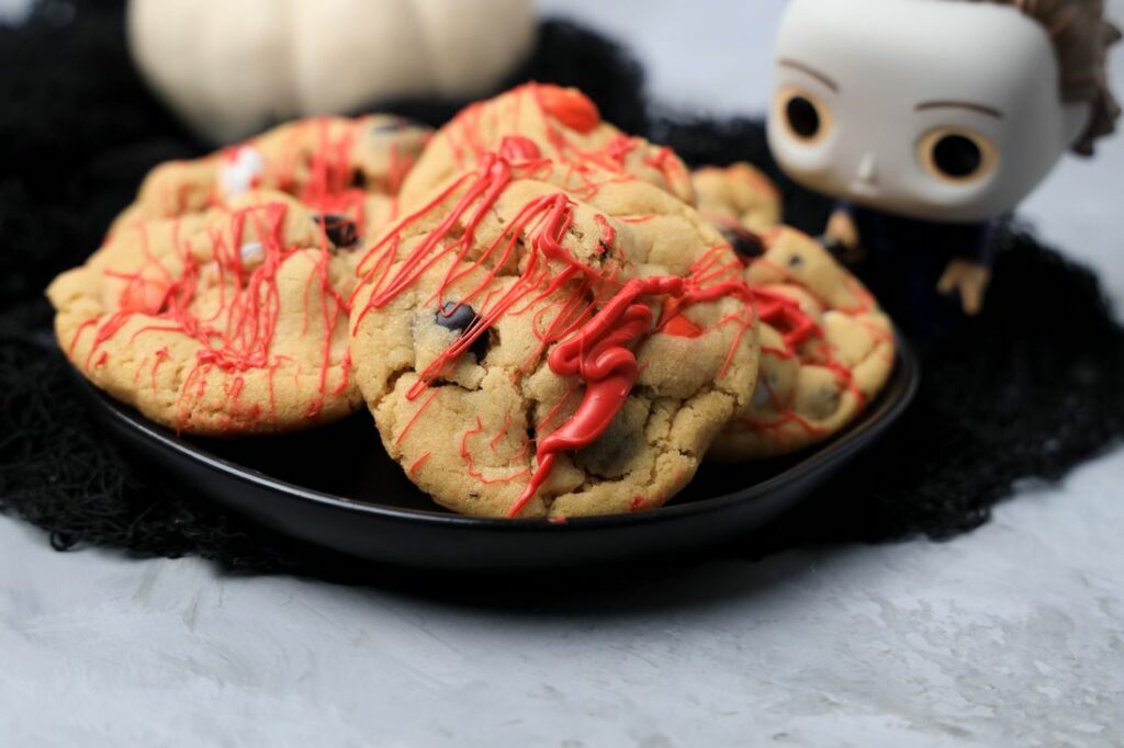 Halloween Michael Myers Bloody Cookies on a black plate with funko pop michael myers in the back.