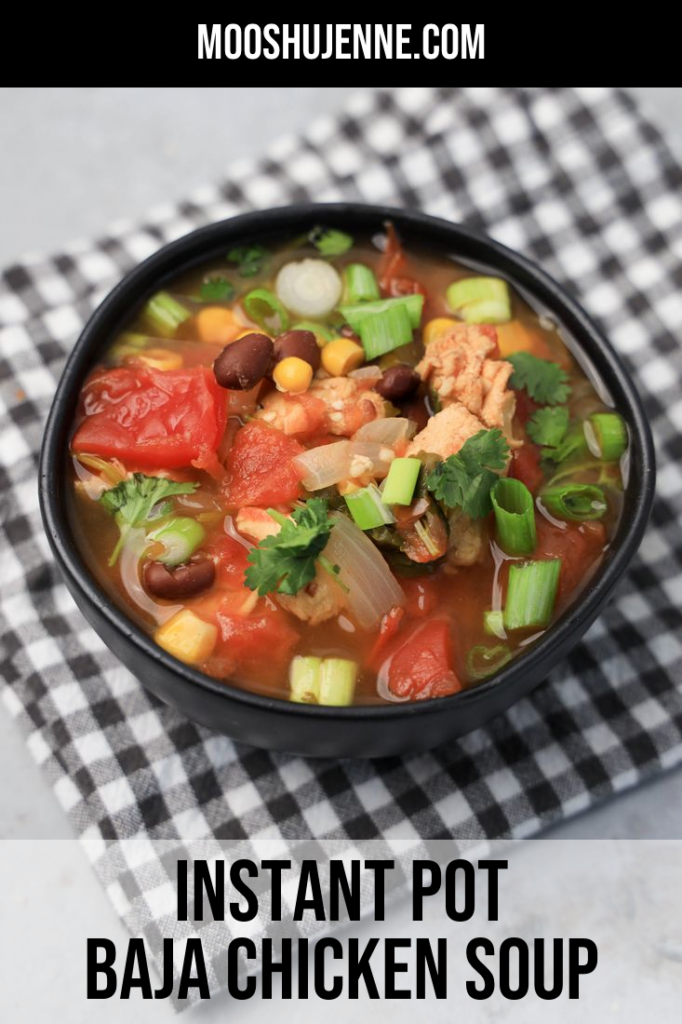 Instant Pot Baja Chicken Soup in a black bowl on a gray plaid napkin with concrete backdrop.