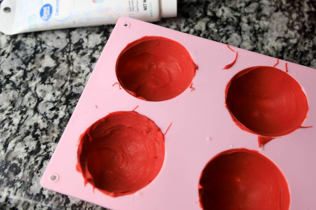 candy melts coating the inside of a large dome mold.