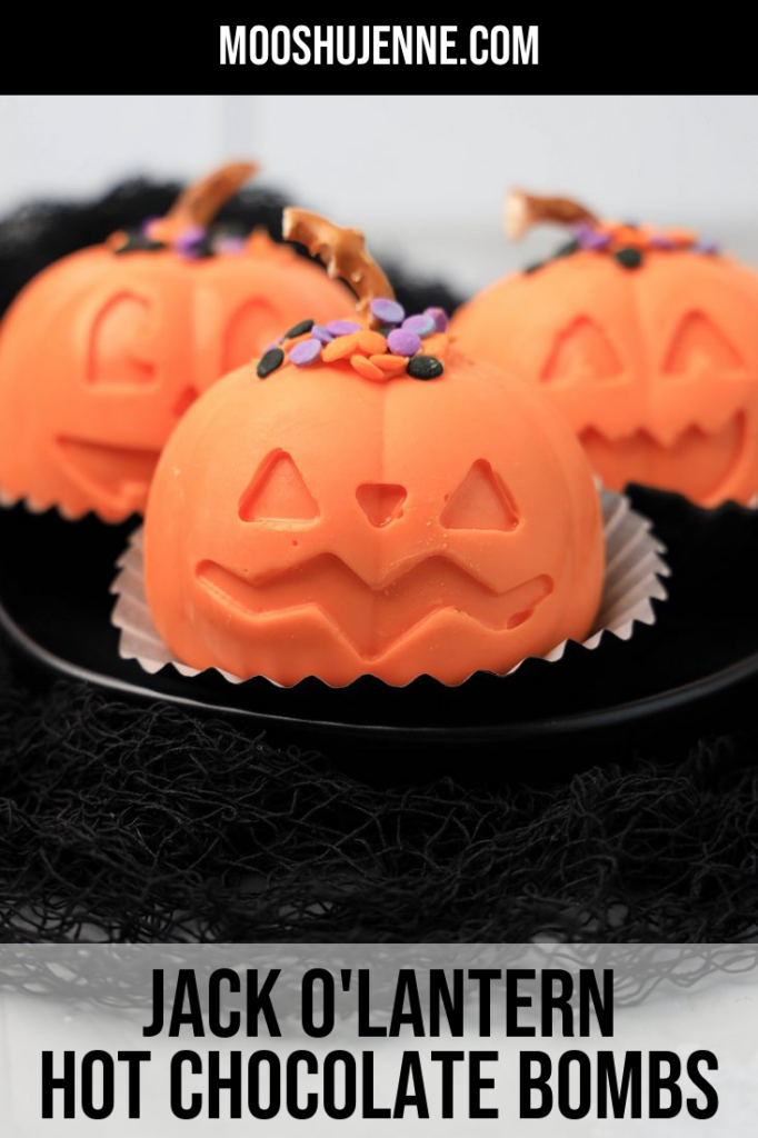 Jack O' Lantern Hot Chocolate bomb on a black plate with black mesh.