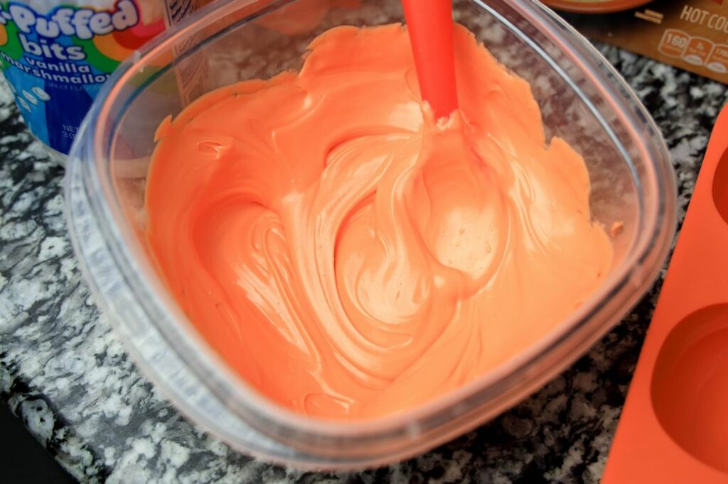 Orange candy melts melted in a bowl.