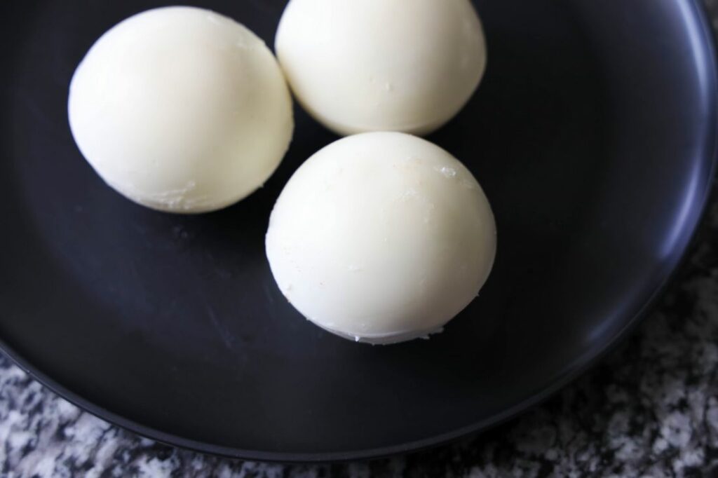 White hot chocolate bombs on a black plate.