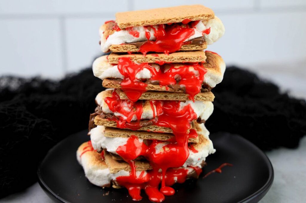 Graham crackers with hershey's chocolate, marshmallows, and red cookie icing.