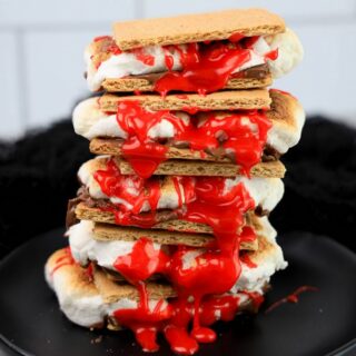 Graham crackers with hershey's chocolate, marshmallows, and red cookie icing.