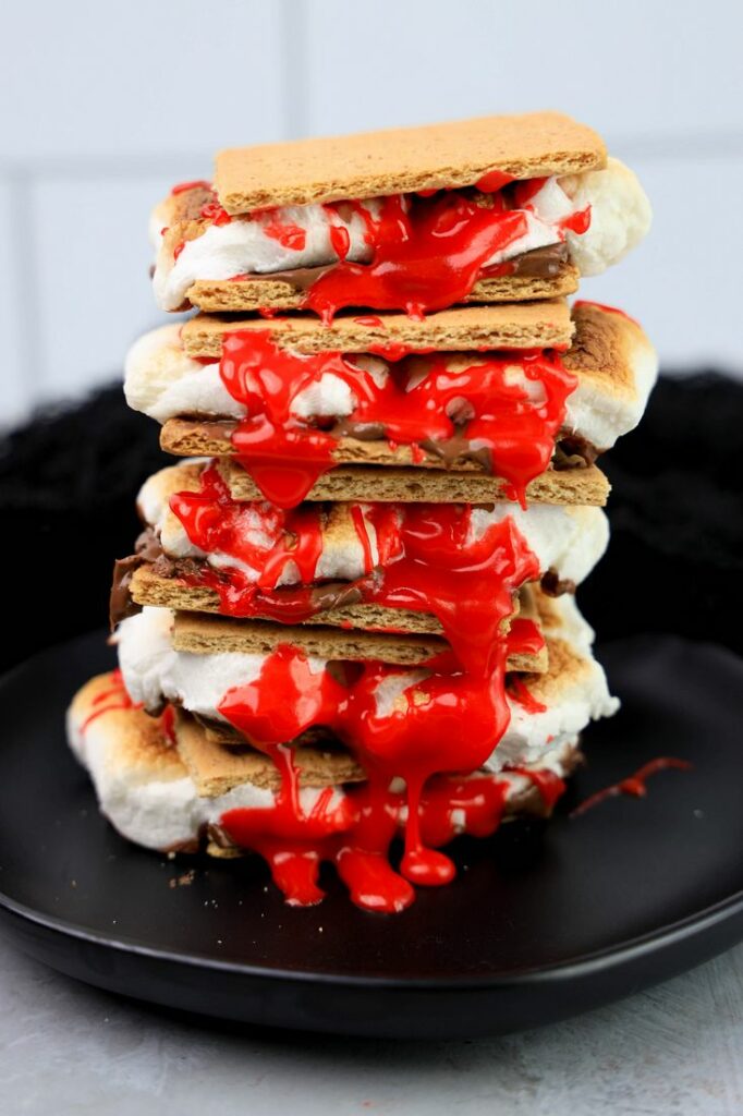 Graham crackers with hershey's chocolate, marshmallows, and red cookie icing.