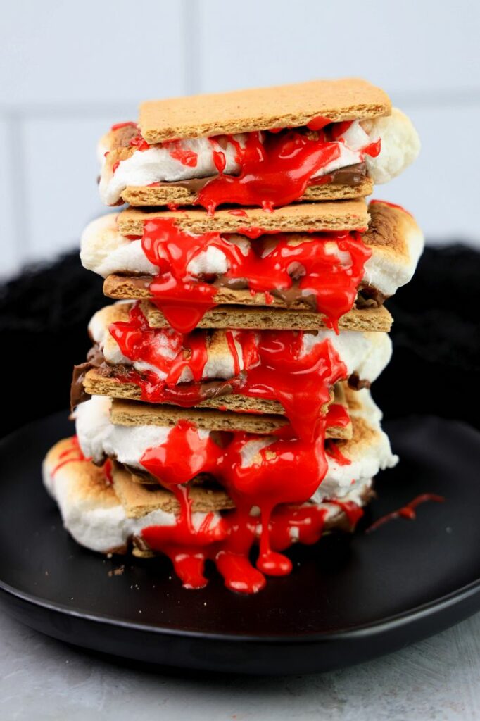 Graham crackers with hershey's chocolate, marshmallows, and red cookie icing.