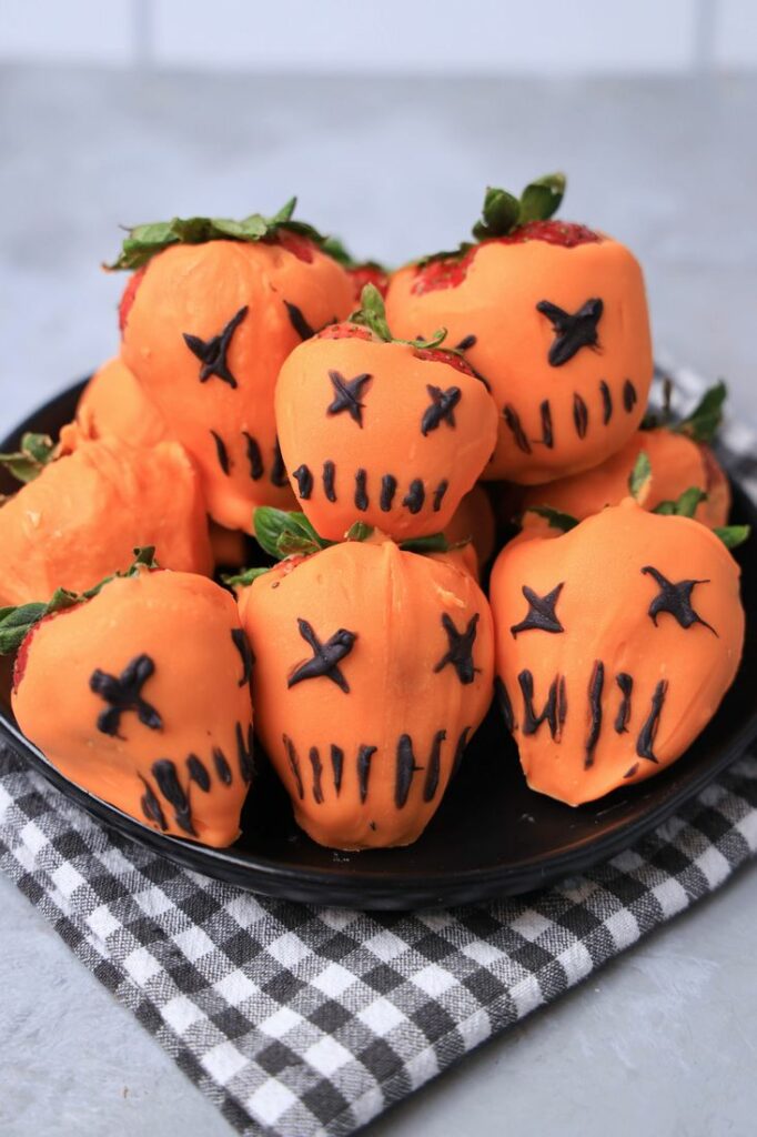 Strawberries covered in orange candy melts and decorate with black candy melts to look like the pumpkin from Trick 'R Treat.