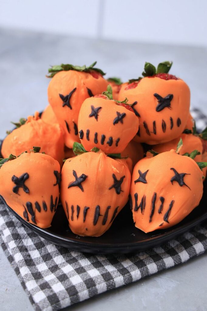 Strawberries covered in orange candy melts and decorate with black candy melts to look like the pumpkin from Trick 'R Treat.