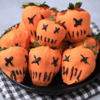 Strawberries covered in orange candy melts and decorate with black candy melts to look like the pumpkin from Trick 'R Treat.