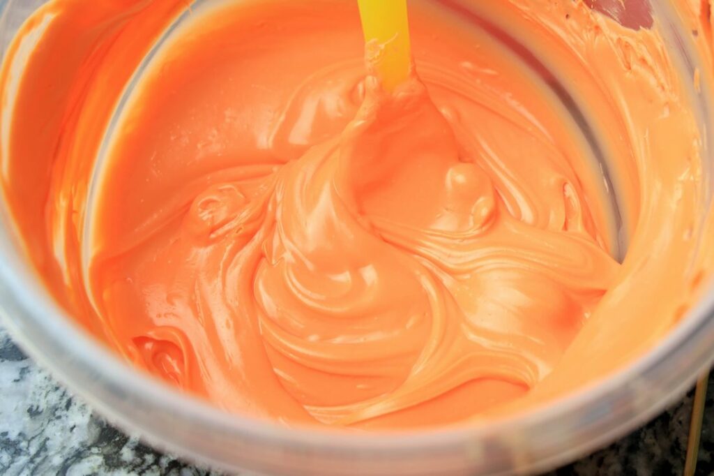 Orange candy melts melted in a bowl