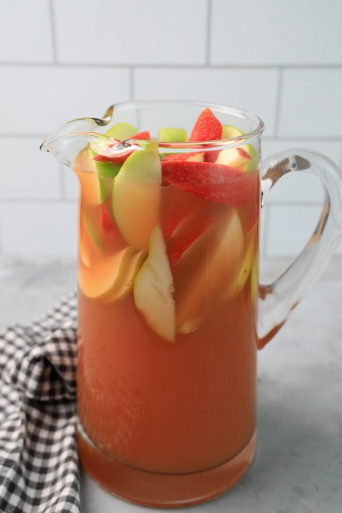 Punch in a glass pitcher with honey crisp apples and granny smith apples.